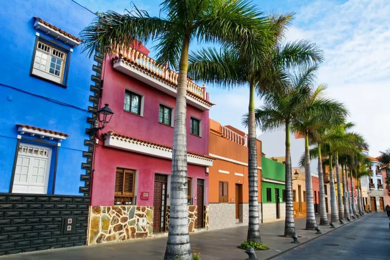 Kleurrijke huizen en palmbomen op straat in Puerto de la Cruz, Tenerife, Canarische Eilanden.